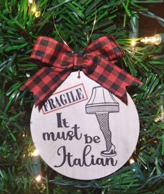 a christmas ornament hanging on a tree with red and black plaid ribbon that says fragile it must be italian