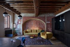 a living room filled with furniture next to a wall mounted flat screen tv on top of a wooden floor