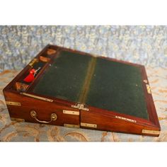 an old wooden suitcase sitting on top of a bed