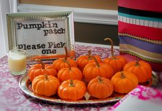 there are many small pumpkins on the plate next to a glass of orange juice