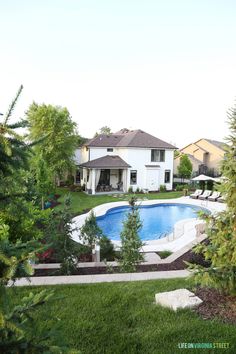 a large backyard with a pool surrounded by trees