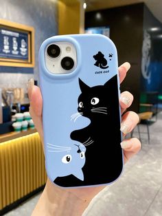 a person holding up a phone case with a cat and fish design on the back