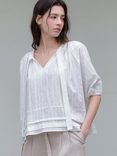 This is a minimal and feminine top by ourcomos that is made out of high quality and sturdy material. With distinctive mood of the design and comfortable wear, you can use it for your daily lifestyle.- V Neckline and long tie- Banding on the sleeve for balloon shape- Modern and minimal mood Modern Linen Tops For Casual Wear, Modern Linen Tops For Casual Gatherings, Elegant White Tops For Casual Gatherings, Effortless Spring Blouse For Everyday, Modern Linen Blouse For Spring, Modern Linen Tops For Daywear, Elegant Linen Top For Day Out, Modern Linen Blouse For Work, Effortless V-neck Blouse For Spring