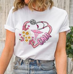 a woman wearing a white t - shirt with pink flowers and a stethoscope on it