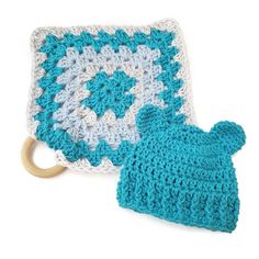 a blue and white crocheted hat next to a knitted baby's mitt