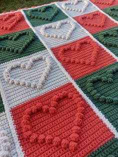 a crocheted blanket with hearts on it