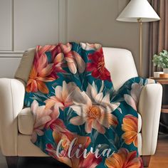 a couch with a blanket on it that has flowers and the name clara printed on it