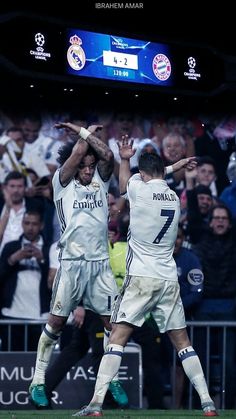 two soccer players are celebrating on the field