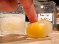 a person is squeezing an orange into ice cubes