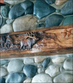 an animal carved into the side of a stone wall with rocks and stones around it