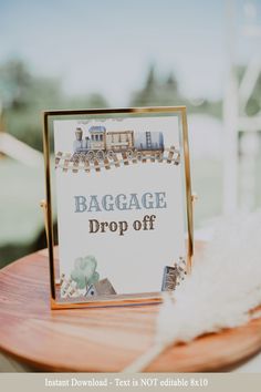 a sign that says baggage drop off sitting on top of a wooden table next to a white feather