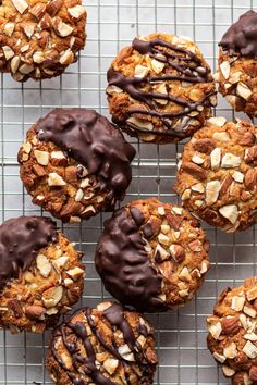 several cookies with chocolate frosting and nuts on a cooling rack