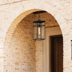 a light hanging from the side of a brick building next to a door and window