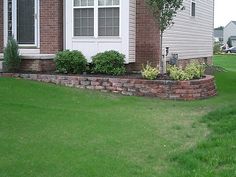 a red fire hydrant in front of a brick house