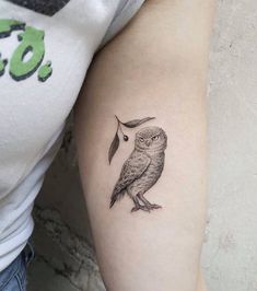 an owl tattoo on the left arm