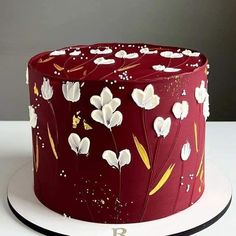 a red cake with white flowers on it