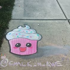 a chalk drawing of a pink cupcake with sprinkles on the sidewalk