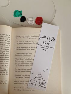 an open book with arabic writing on it and some crayons next to it