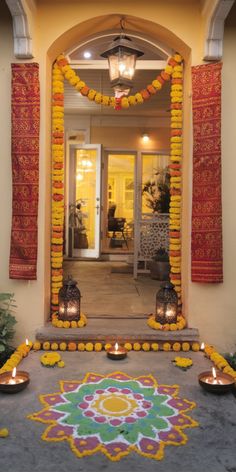 an entrance decorated with flowers and candles for diwaling on the day of diwaling