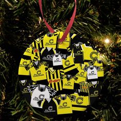 a yellow and black ornament hanging from a christmas tree