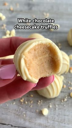 a hand holding a piece of white chocolate cheesecake truffles