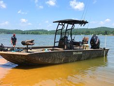 a man standing in the water next to a boat with outboard motor on it