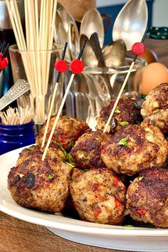 a plate full of meatballs with toothpicks stuck in them