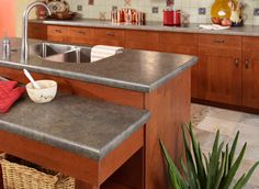 a kitchen with wooden cabinets and granite counter tops, along with a stainless steel sink