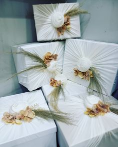 four white boxes with flowers on them are stacked next to each other in a pile