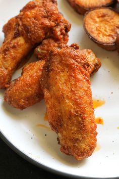 fried chicken wings on a white plate with sliced banana's and eggplant