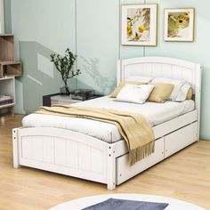 a white bed sitting on top of a hard wood floor next to a book shelf