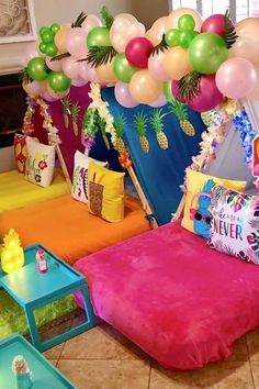 a room decorated with balloons and pineapples