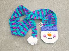 a knitted snowman hat and scarf on the ground