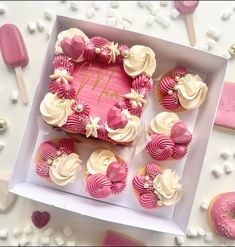 a box filled with pink and white cupcakes