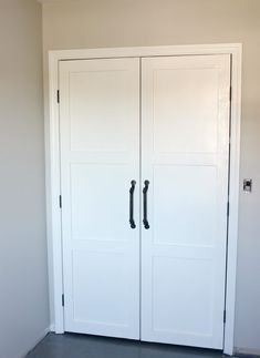 two white doors are open in a room