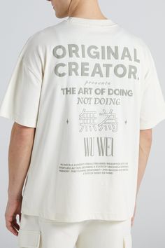 a man wearing a white t - shirt that reads, original creator the art of doing not doing