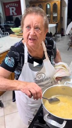 an older woman cooking food in a pot on the stove top with a spoon and ladle