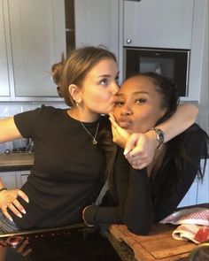 two women in the kitchen kissing each other