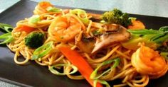 a black plate topped with noodles and vegetables