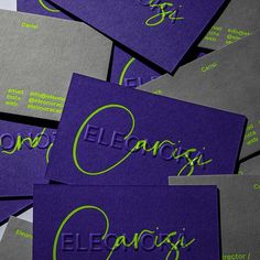 purple business cards with green lettering on them