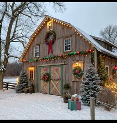 a barn covered in christmas lights and wreaths