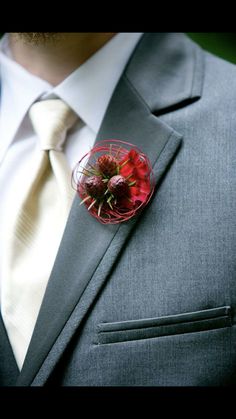 a man wearing a suit and tie with a boutonniere on his lapel