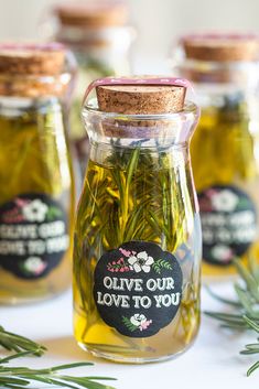 three jars filled with olives and herbs