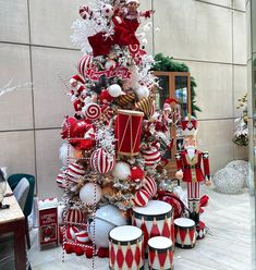 a christmas tree decorated with red and white ornaments, candy canes, nutcrackers and other holiday decorations