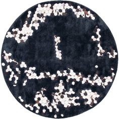 a black rug with white and brown dots on it's center piece, in the shape of a circle