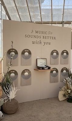 a room with various plants and decorations on the wall, including an advertisement for musical sounds better with you