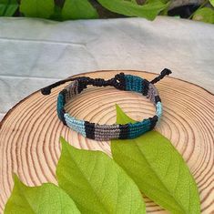 Elevate your boho surfer style with this stunning unisex macrame bracelet in black and green. Handmade with precision and care, this adjustable striped thread bracelet is the perfect addition to any outfit. The intricate weaving of the thread creates a unique and eye-catching design that is sure to turn heads. This bracelet is versatile enough to be worn on its own or layered with other bracelets for a more eclectic look. Made with high-quality polyester waxed thread, this macrame bracelet is a Black Bohemian Macrame Friendship Bracelets, Boho Surfer Style, Thread Bracelet, Green Thread, Surfer Style, Thread Bracelets, Thread Jewellery, Macrame Bracelet, Handmade Macrame