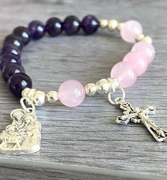 "Item details Handmade Materials Gemstone: Amethyst, Rose Quartz round beads with Holy Family Medal and a small ornate crossRound Beads. Durable high quality stretch cord This will be a great gift for confirmation! A unique and beautiful personalized rosary bracelet! It will make a perfect religious themed gift or inspiration for yourself. The beads used on every piece are handpicked. We make sure that each bracelet includes a range of the natural colors found in the stone It is not guaranteed t Cheap Pink Rosary Bracelet For Gift, Personalized Rosary, Bracelets Design, Rosary Bracelet, Beaded Bracelets Tutorial, Small Crosses, Holy Family, Beads Bracelet Design, Handmade Jewelry Diy