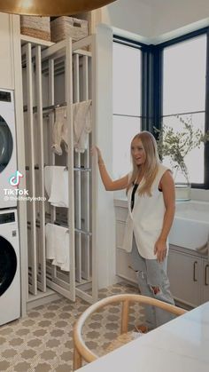 a woman standing in front of a washer and dryer