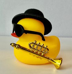 a rubber duck wearing a hat, sunglasses and a trumpet